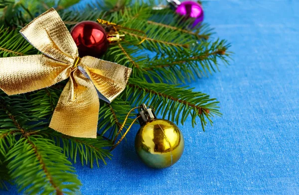 Рождественский фон Ветви ели украшены красочными украшениями на голубой салфетке . — стоковое фото