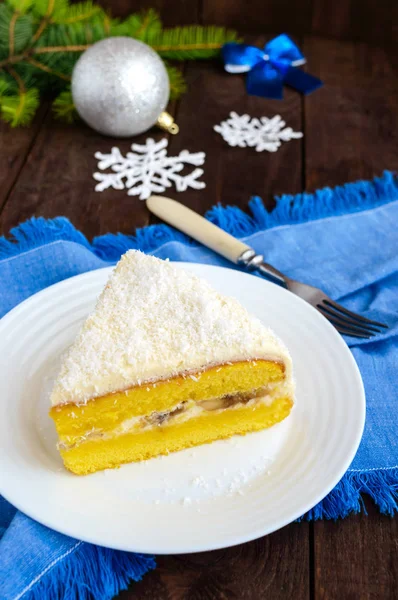 Sanfter Biskuitkuchen mit cremiger Bananenschicht, Kokosnuss darüber streuen. Option festliches Dessert für Weihnachten, Neujahr. Nahaufnahme — Stockfoto