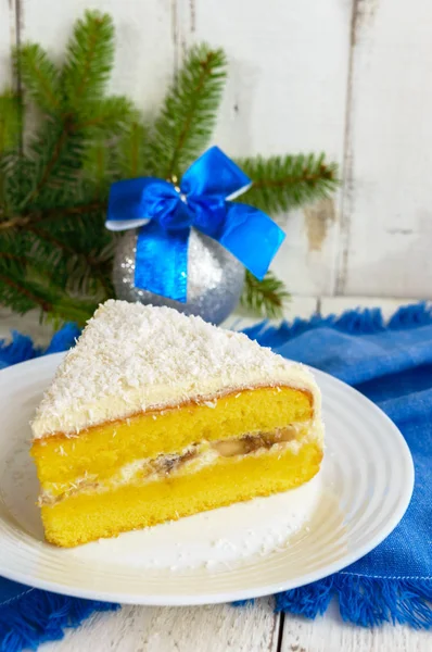 Gentle sponge cake with creamy banana layer, sprinkle coconut on top. Option festive dessert for Christmas, New Year. Close-up — Stock Photo, Image