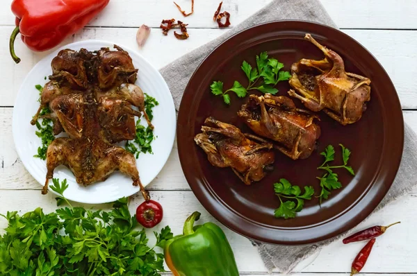 Roasted quail on a spit. Serving on a ceramic plate with greens. The top view. Holiday menu. — Stock Photo, Image