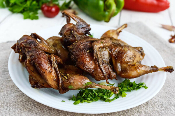 Roasted quail. Serving on a plate with greens. Close-up. Holiday menu.