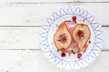 Tatlı pişmiş armut ahududu şurubu ve şeker taze ahududu süzme peynir ile doldurulmuş. Tatlı Beyaz ahşap zemin üzerinde. Üstten Görünüm.