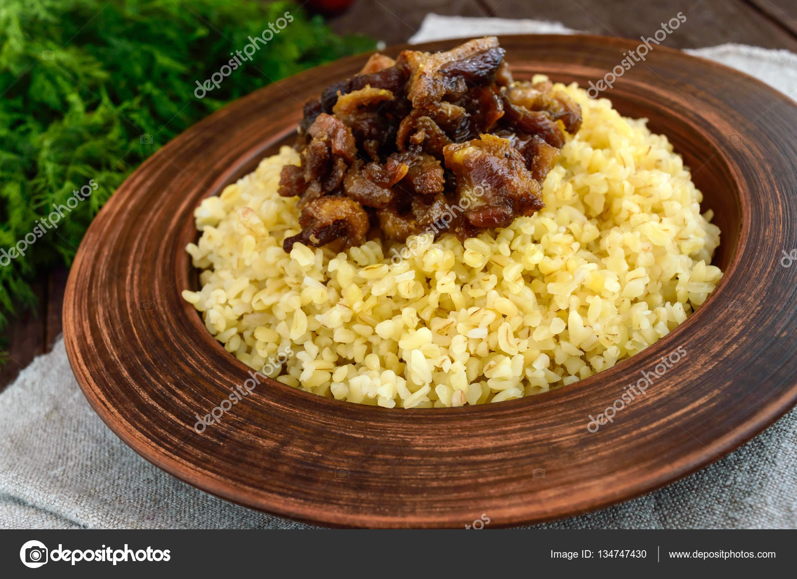 东方传统小麦粥-小麦与烤的块脂肪肉类、 培根在黑暗的木制背景上的粘土碗。关闭——图库图片© iaroshenko.marina.gmail.com  #134747430