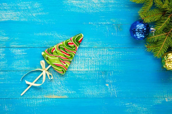 Рождественские угощения: красочные леденцы в виде ели на голубой деревянной доске. Праздничный фон . — стоковое фото