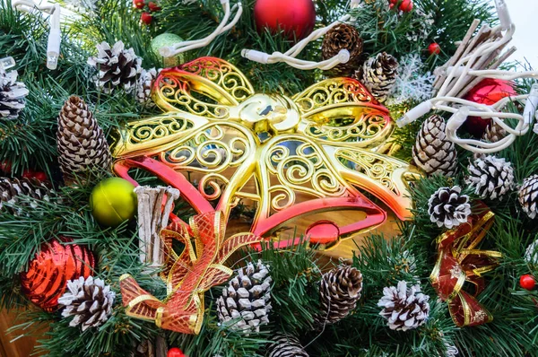 Grandi campane di plastica di traforo d'oro, rami di abete, coni - decorazioni festive per l'Anno nuovo, il Natale. Decorazione cortile interno, strada. Da vicino. — Foto Stock
