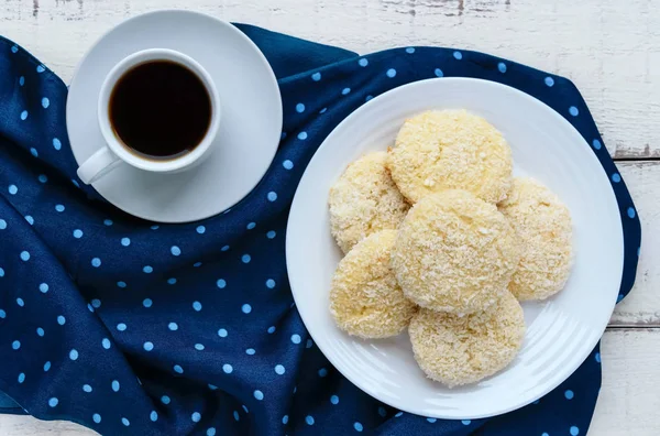 Ropogós diétás kókuszos cookie-k egy lemez és egy csésze kávét a fehér fa háttér. Szemközti nézet — Stock Fotó