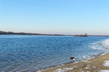 Kış manzarası. Bir görünümü geniş nehir. Boş bir kıyıda - buz parçaları. Soğuk sezon. Açık gün.