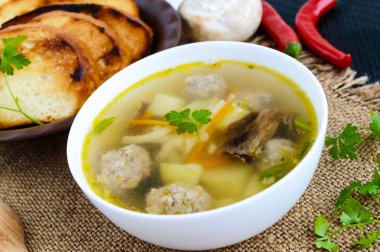 Hafif çorba kurutulmuş mantar, köfte ve maccheroni beyaz bir kase. Yakın çekim.