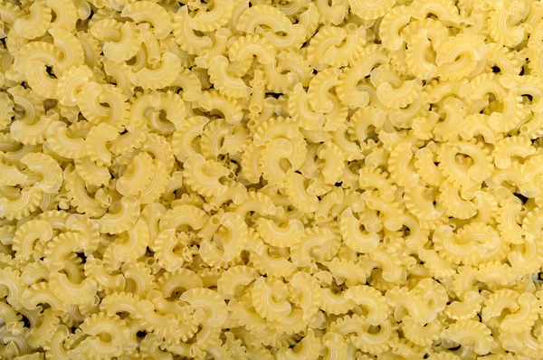 Raw macaroni - pasta Galetti closeup. Background texture. — Stock Photo, Image