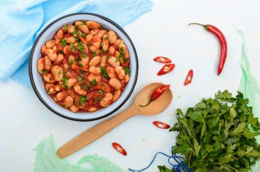 Tatlı ve ekşi domates soslu bir kase hafif bir arka plan üzerinde beyaz büyük fasulye. Üstten Görünüm. Vejetaryen mutfağı. Paskalya yemek.