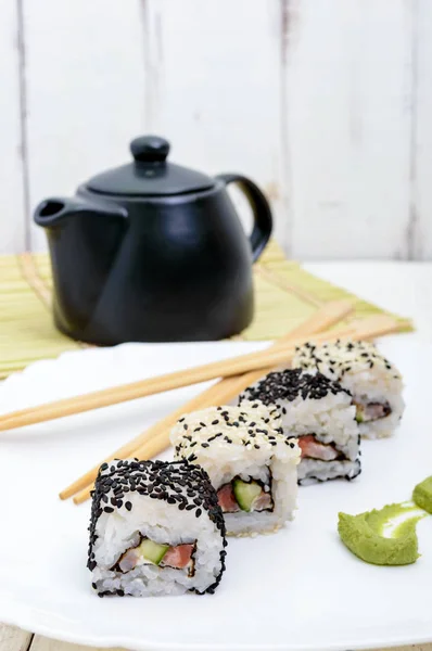 Piatto orientale tradizionale con salmone, gamberetti - involtini di sushi su un piatto bianco — Foto Stock