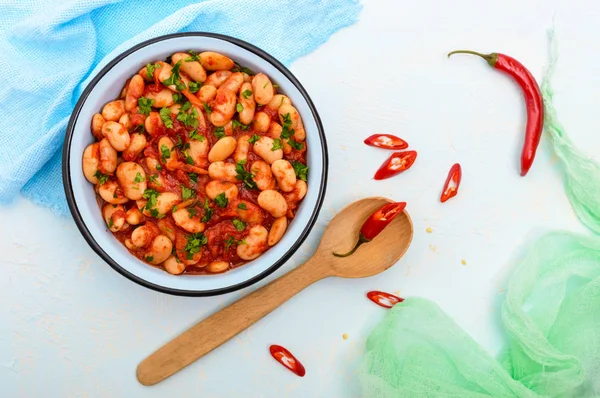 Tatlı ve ekşi domates soslu bir kase hafif bir arka plan üzerinde beyaz büyük fasulye. Üstten Görünüm. Vejetaryen mutfağı. Paskalya yemek.