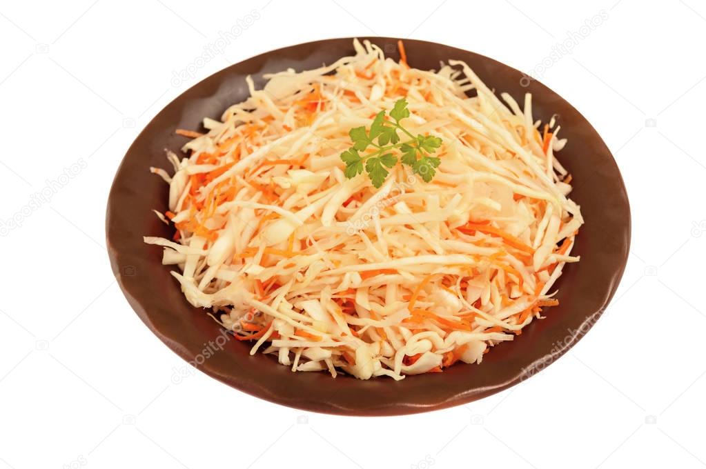 Salad of fresh cabbage and carrots in a clay bowl on a white background is insulated.