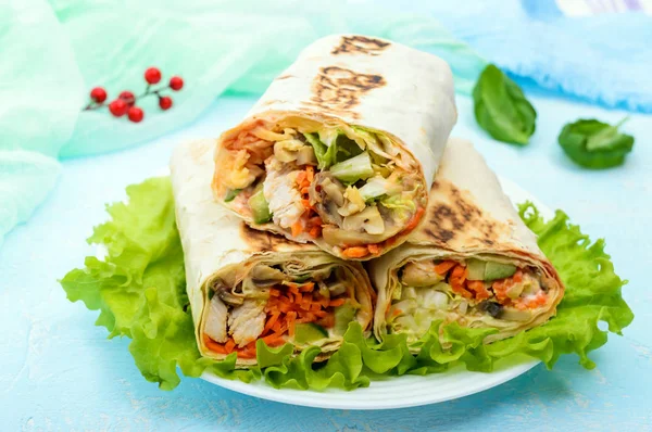 Shawarma - Piatto mediorientale a base di lavash (pita), farcito con pollo, funghi, insalata di verdure fresche, salsa. Servire su foglie di lattuga su uno sfondo leggero . — Foto Stock