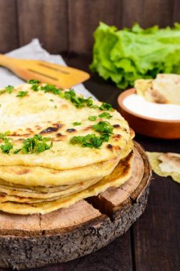 İnce gözleme - geleneksel Asya koyu ahşap arka plan üzerinde ekmek. Dikey Görünüm