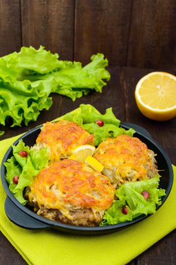 Sulu et pirzola, fırında rendelenmiş patates ve koyu ahşap arka plan üzerinde dökme demir tava üzerine peynir ile. Dikey Görünüm