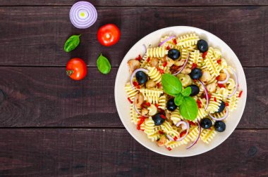 Tavuk, Siyah Zeytin, mavi soğan, tatlı biber koyu ahşap arka plan ile makarna salatası radiatori. Üstten Görünüm.