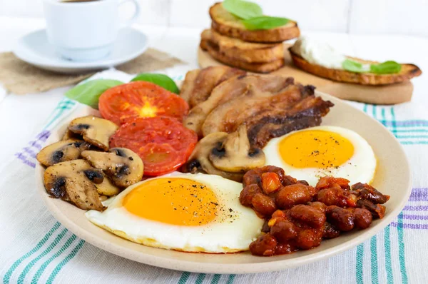 Angielskie śniadanie: jajka, bekon, fasola, sos pomidorowy, pieczarki, pomidory, Grzanka z twarogiem — Zdjęcie stockowe