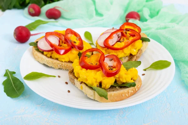 Sandwich with scrambled eggs, rucola, radish, paprika kapi and flax seeds — Stock Photo, Image