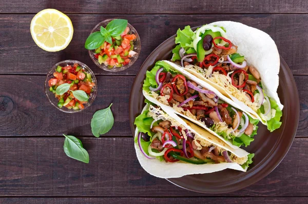 Tacos adalah hidangan tradisional Meksiko. Tortilla diisi dengan ayam, lonceng dan paprika panas, kacang, selada, keju, bawang biru dengan saus salsa — Stok Foto