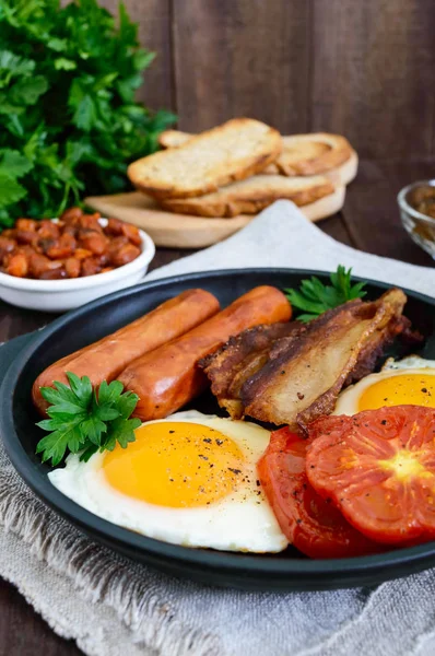 Colazione all'inglese: salsicce, pancetta, pomodori, uova, fagioli in salsa, funghi fritti, toast — Foto Stock