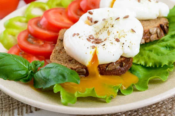 Sanduíche com ovo escalfado, alface, pão preto com sementes, tomate, pimenta doce — Fotografia de Stock
