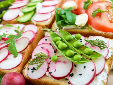 Sebzeli sandviç birkaç tür: turp, domates, salatalık, roka 