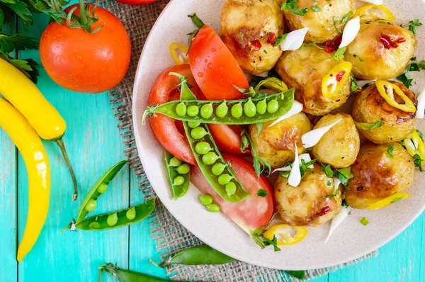 Salade épicée de pommes de terre cuites au four, jeune ail, tomates, pois verts — Photo