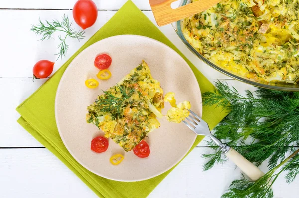 Цветная капуста с сыром, зеленью и яйцом. Большой кусок на тарелке . — стоковое фото