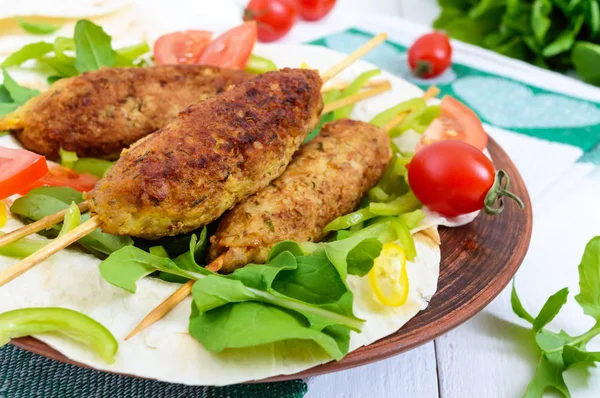 Carne picada em espetos - kebabs de lula em uma chapa com verduras frescas — Fotografia de Stock