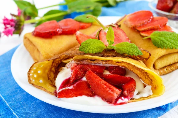 Panqueques calados con un delicado cuajada (helado) y fresas frescas, menta en un plato . —  Fotos de Stock