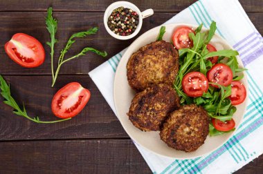 Bir tabak salata, domates ve roka ile sulu pirzola