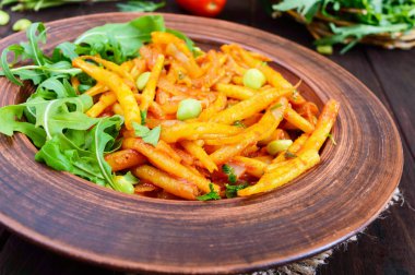 Roka yeşil fasulye, domates sosu ve yeşil soğan ile demlenmiş üzerinden salata yaprakları 