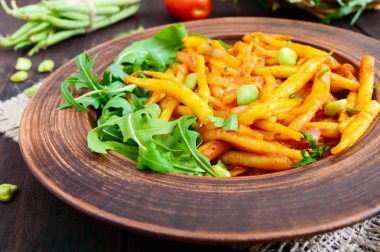 Roka yeşil fasulye, domates sosu ve yeşil soğan ile demlenmiş üzerinden salata yaprakları 