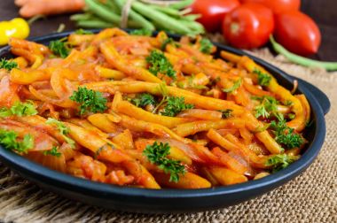 Baharatlı yeşil fasulye ile soğan, havuç, domates sos ihtiva eder.