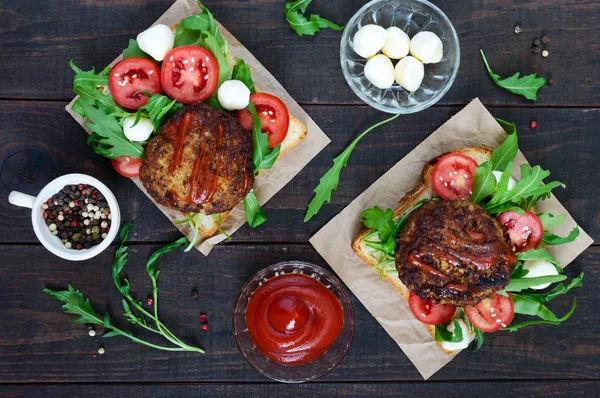 Сочный бургер на буханке хлеба с рукколой, моцареллой и помидорами — Бесплатное стоковое фото