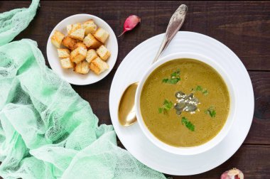 Kremalı sebze çorbası ıspanak ve patates sarımsak croutons koyu ahşap arka plan üzerinde beyaz bir kase. Diyet Vejetaryen Menü. Doğru beslenme.