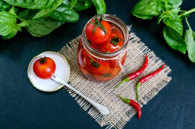 Siyah bir arka plan cam kavanozda ekşi domates. Turşu