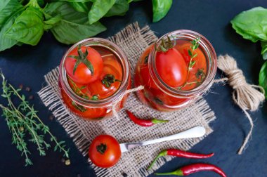 Siyah bir arka plan cam kavanozda ekşi domates. Turşu