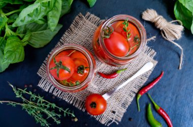 Siyah bir arka plan cam kavanozda ekşi domates. Turşu