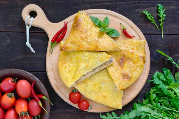 Khachapuri etli - koyu ahşap bir masa üzerinde geleneksel Gürcü böreği. Üstten Görünüm.