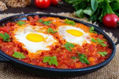 Shakshuka - bir fincan domates, acı biber, soğan ve baharat soslu kızarmış yumurta. 