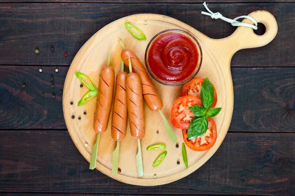 Сосиски на шампуре с кетчупом и свежими помидорами — стоковое фото