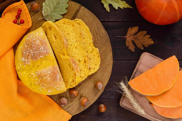 Kabak ekmek koyu ahşap bir masa üzerinde parçalar halinde kesilmiş.