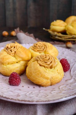 Lezzetli bir seramik tabak karamel fındık kremalı profiterol 