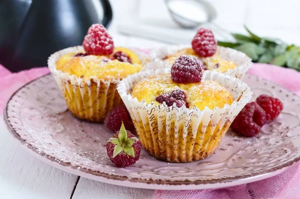 Delicious freshly baked muffins with raspberries, decorated with powdered sugar — Stock Photo, Image