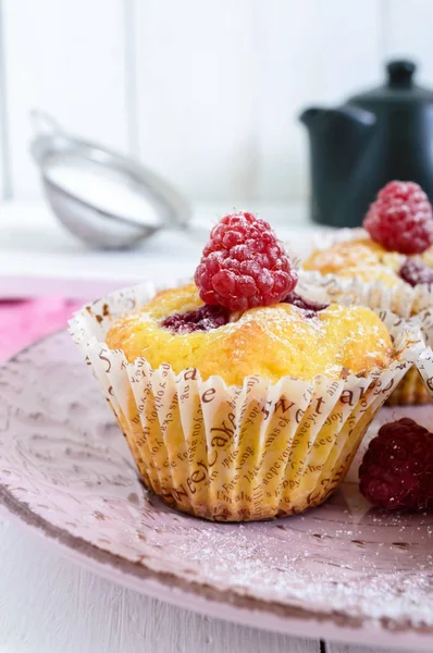 Deliziosi muffin appena sfornati con lamponi, decorati con zucchero a velo — Foto Stock