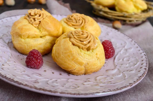 Lezzetli bir seramik tabak karamel fındık kremalı profiterol 