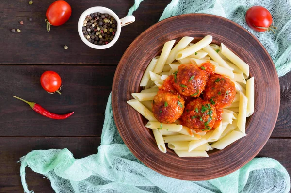 Massa Penne com bolas de carne em molho de tomate em uma tigela de barro — Fotografia de Stock