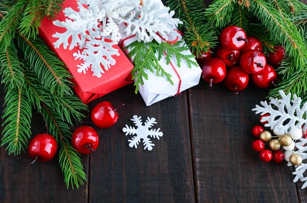 Новый год, рождественская тема. Подарочные коробки, зеленые ели, ягоды — стоковое фото